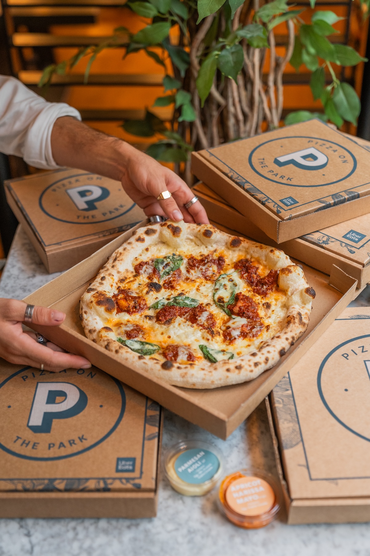 A mouth-watering pizza fresh out of the oven being boxed for collection at Pizza on the Park, the go-to pizza restaurant for office catering in Bristol. The branding on the pizza boxes makes it clear that this is a premium catering service, ideal for businesses in Clifton seeking top-quality pizzas for corporate lunches, client meetings, and office gatherings. With a focus on local ingredients and a variety of flavours, Pizza on the Park offers customized catering options for every office event.